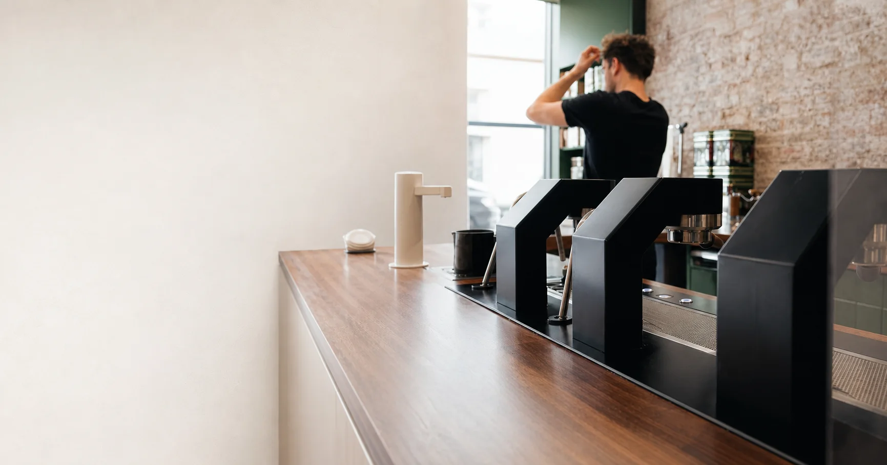 A barista working behind a modern espresso machine